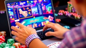 Person playing online casino game on laptop with chips.